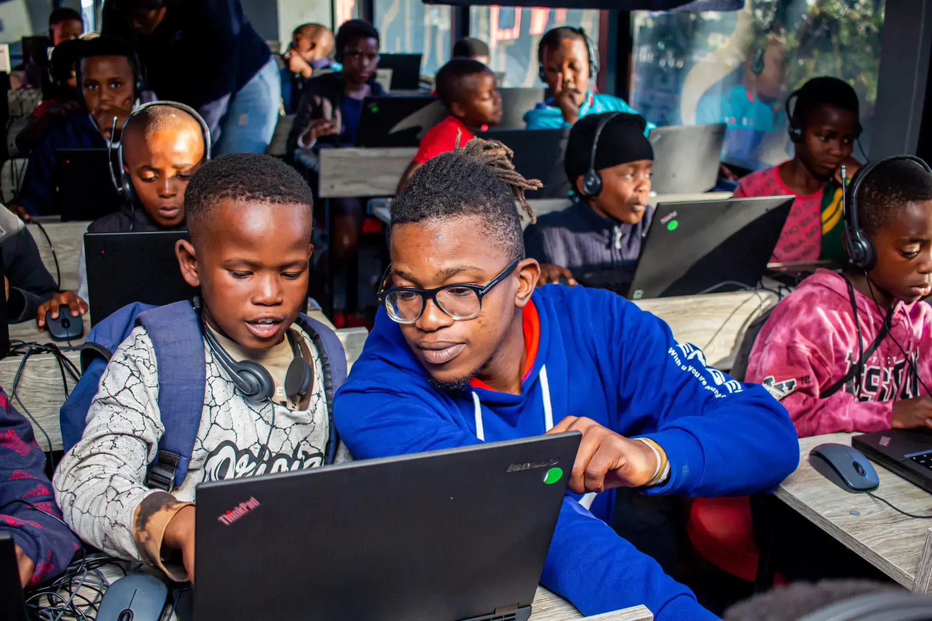 A facilitator guiding a learner through the programme on a laptop