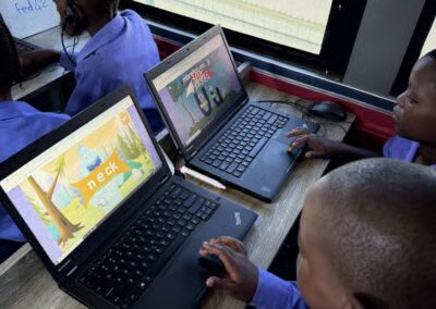 Learners using literacy learning software on laptops inside the DigiBus