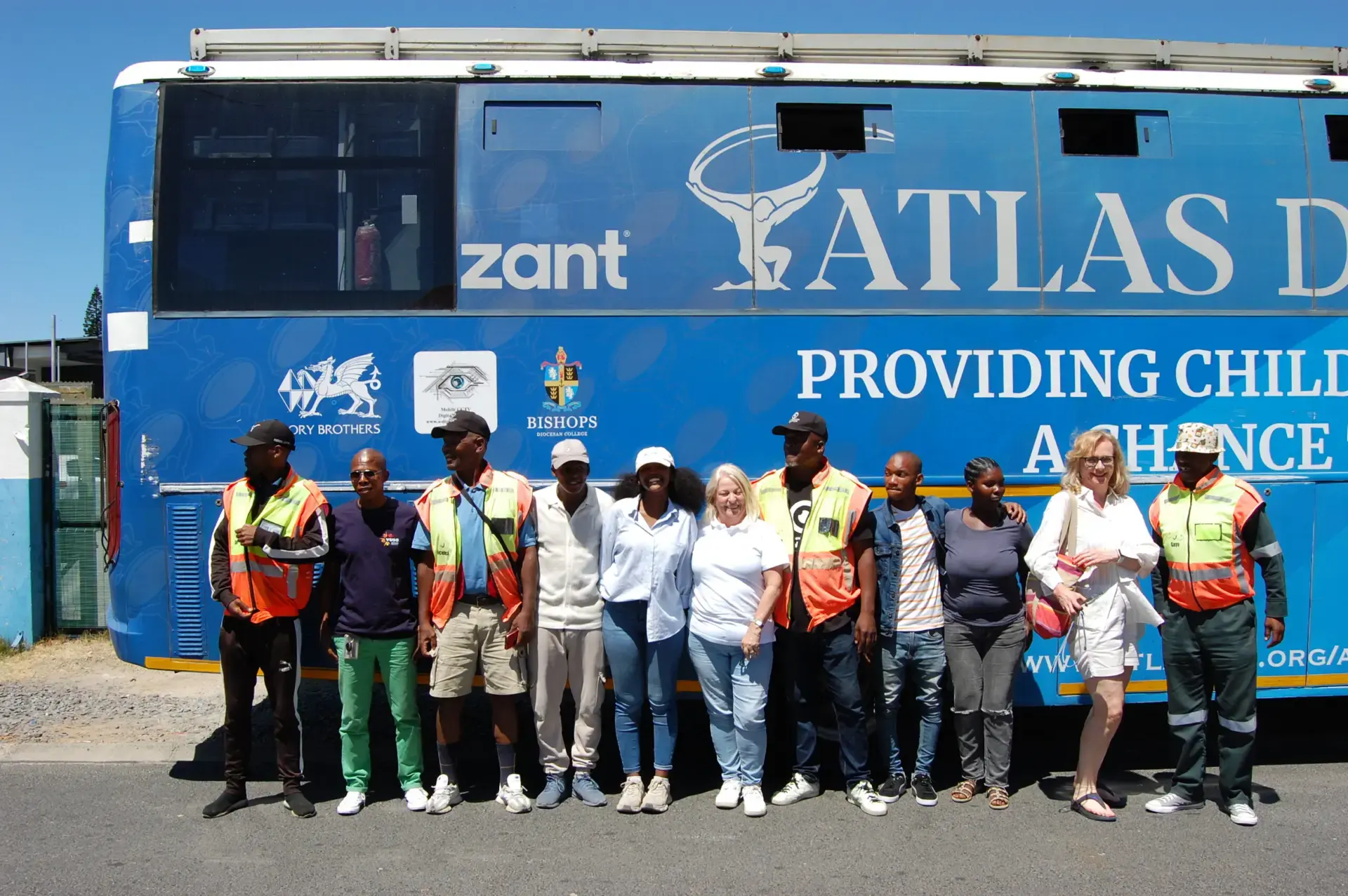 Delivery team and community partners standing in front of the Atlas DigiBus